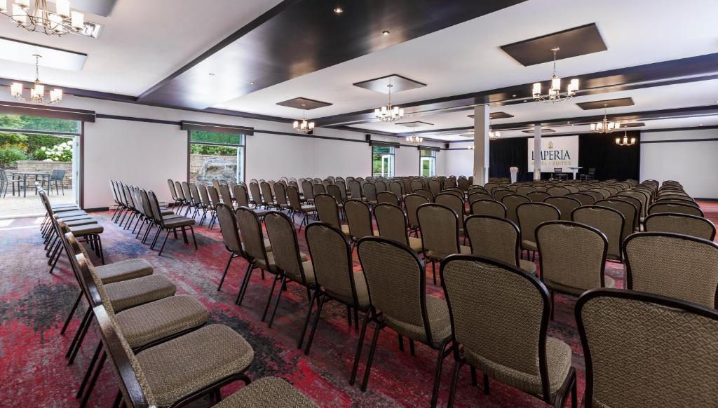 a row of chairs in a room with a stage at Imperia Hotel & Suites Saint-Eustache in Saint-Eustache