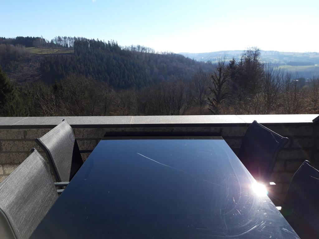 a table on a balcony with a view of a mountain at Terrasses de Malmedy - Duplex 455 in Malmedy