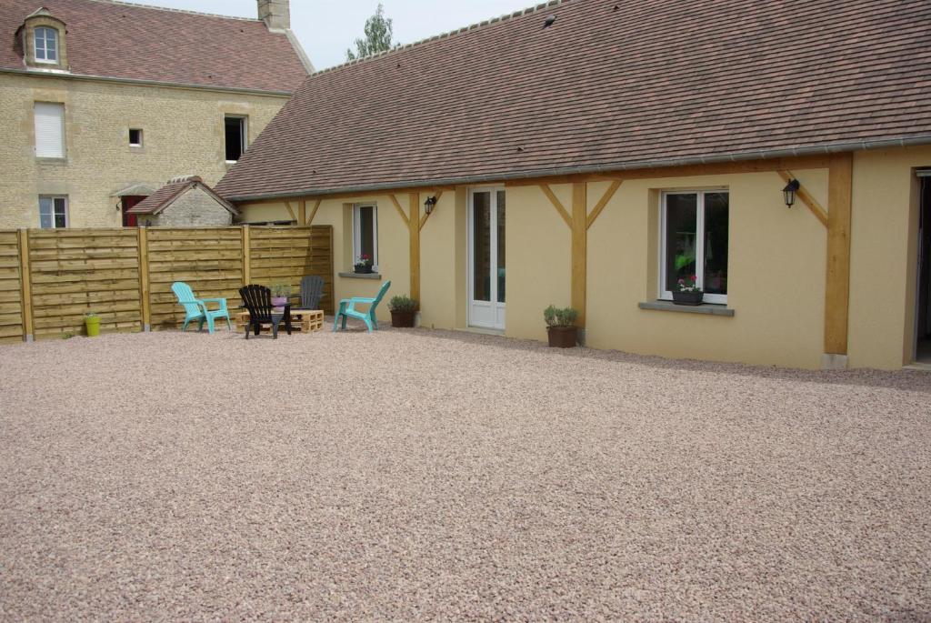 un patio con una casa y una valla en GRANGE du BOSQUET en Vendeuvre