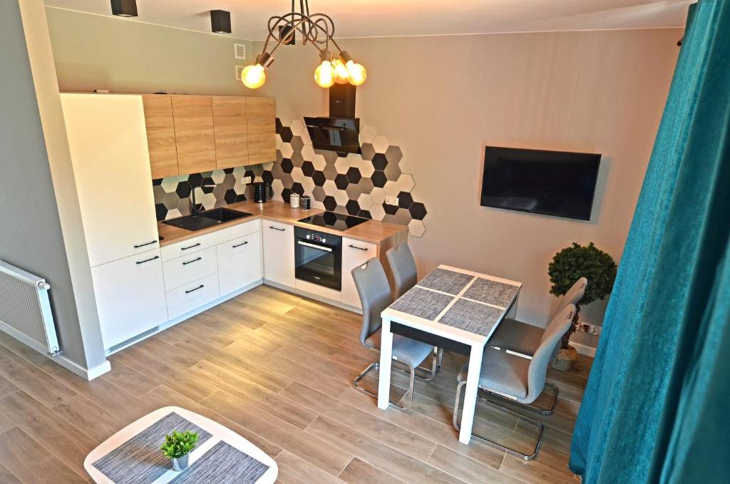 a kitchen and dining room with a table and chairs at Apartament RELAKS w spokojnej okolicy - SUN&SPORT in Szczyrk