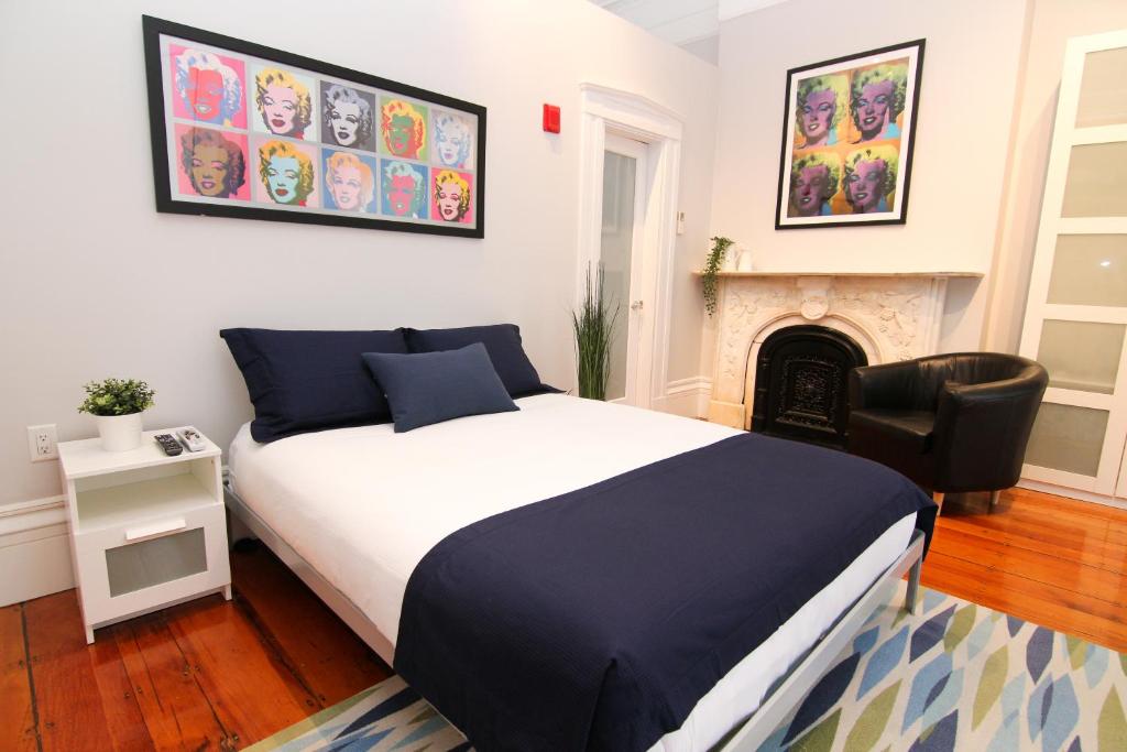 a bedroom with a bed and a chair and a fireplace at Charming & Stylish Studio on Beacon Hill #8 in Boston