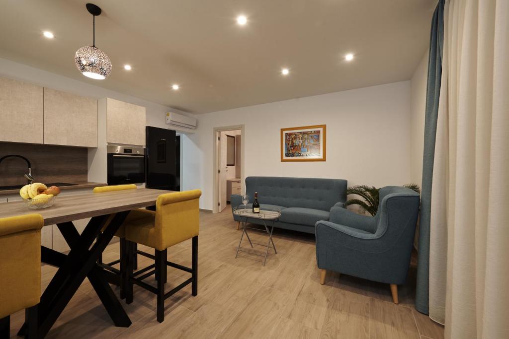 eine Küche und ein Wohnzimmer mit einem blauen Sofa und einem Tisch in der Unterkunft SUNNY SIDE in Trogir