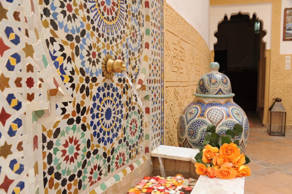 Cette chambre est dotée d'un mur recouvert de carrelage coloré. dans l'établissement Riad Shaden, à Marrakech