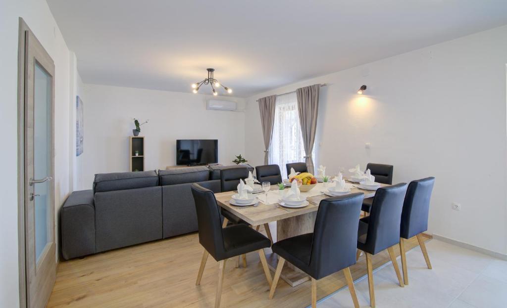 ein Esszimmer mit einem Tisch, Stühlen und einem Sofa in der Unterkunft Josipa & Jelena Apartment in Senj