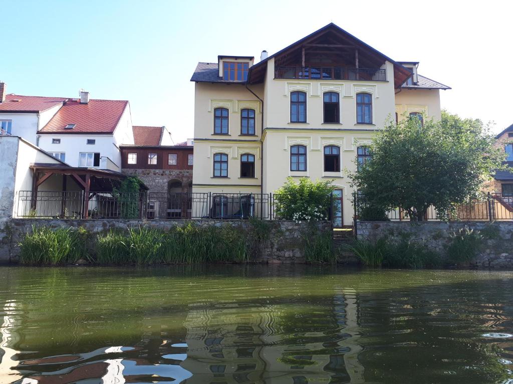 Apartmány Šetkova vila في جينديتشوف هراديك: مبنى بجانب تجمع المياه