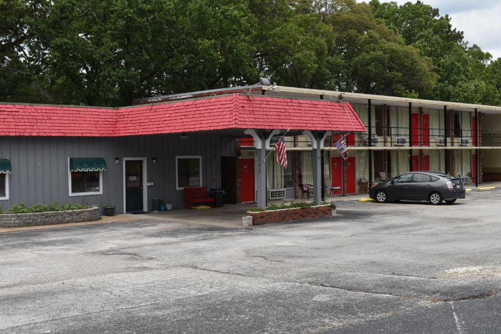 un coche aparcado frente a un edificio con techo rojo en Thurman's Lodge en Eureka Springs