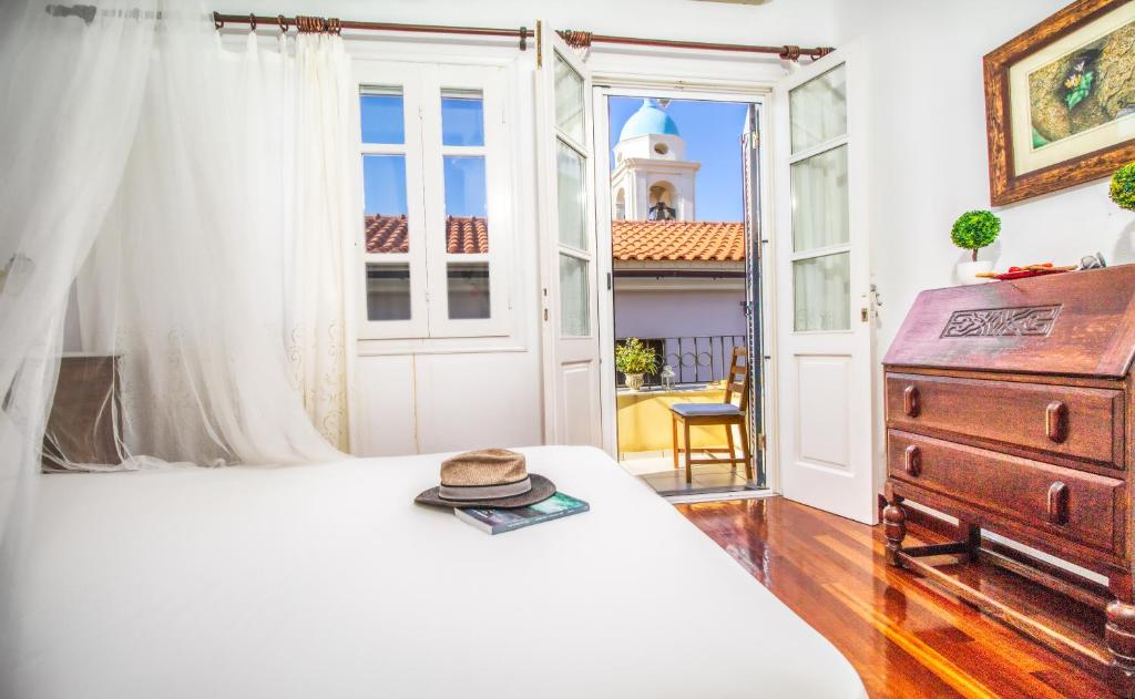 un cappello su un letto in una stanza con finestra di Chanialiving Venetian Luxury House a Chania