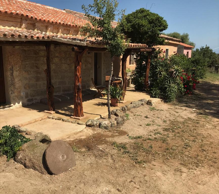 ein Haus mit einem Baumstumpf davor in der Unterkunft Li Casacci in Arzachena