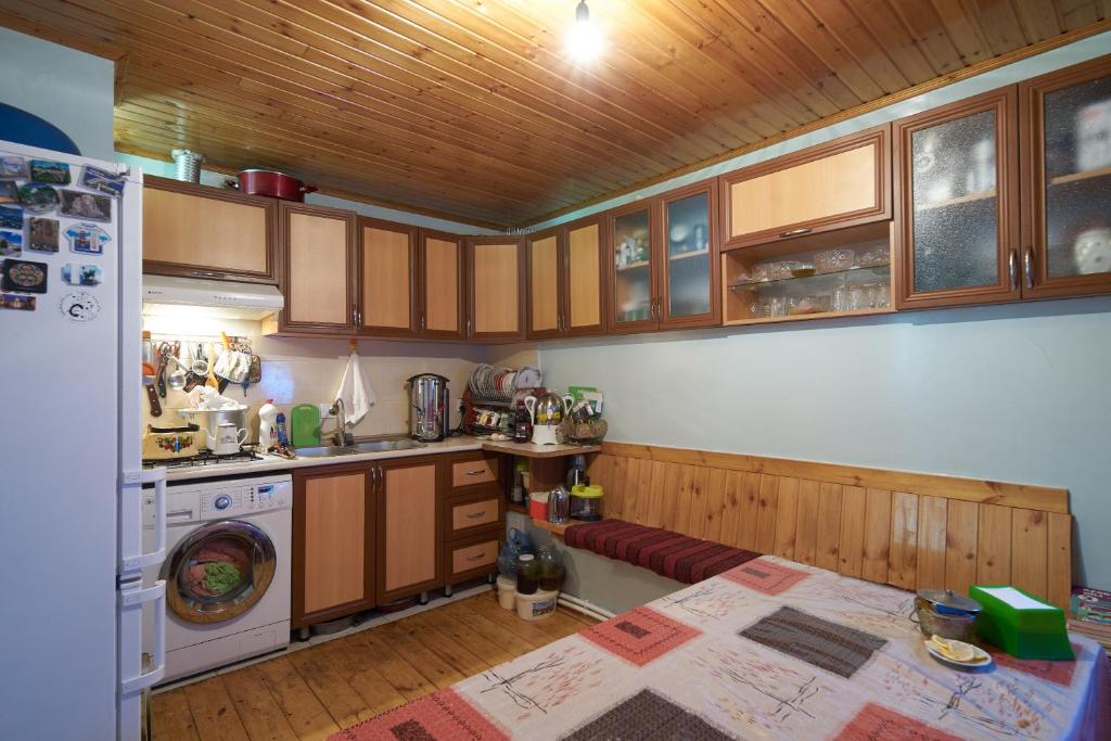 a kitchen with wooden cabinets and a stove and a refrigerator at Ancient Lahij Guest House in Lahıc