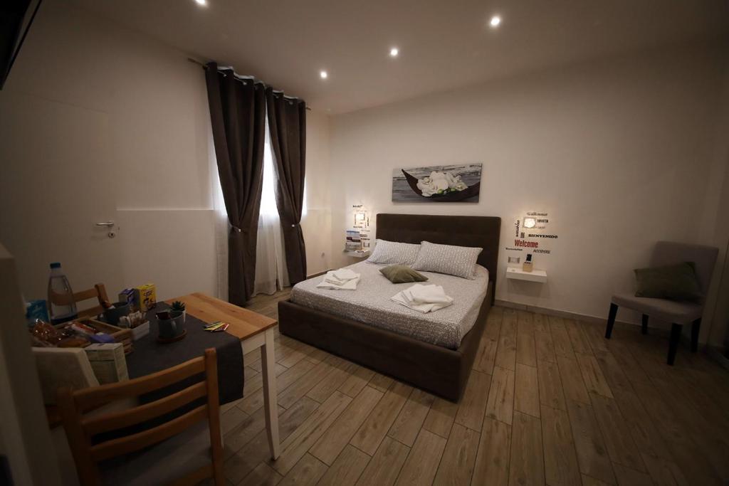 Un dormitorio con una cama y una mesa. en La piazzetta en Brindisi