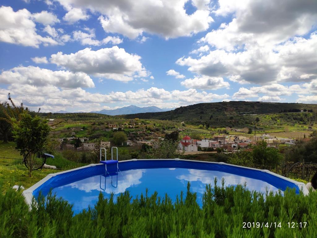a swimming pool with a view of the mountains at Green Farm-small paradise! in Kalloní
