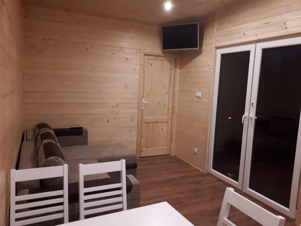 ein Wohnzimmer mit einem Sofa und einem TV in der Unterkunft Sarzynówka pod Sosną in Krasnobród