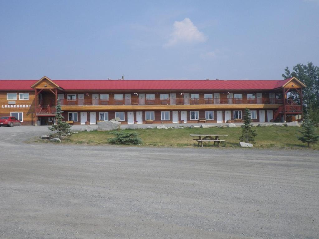 ein großes Gebäude mit einem Picknicktisch davor in der Unterkunft Alcan Motor Inn in Haines Junction