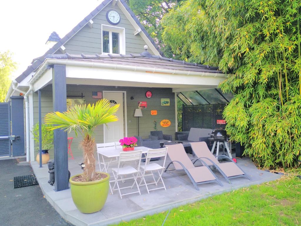 a patio with a table and chairs and a house at La louisiane in Montivilliers