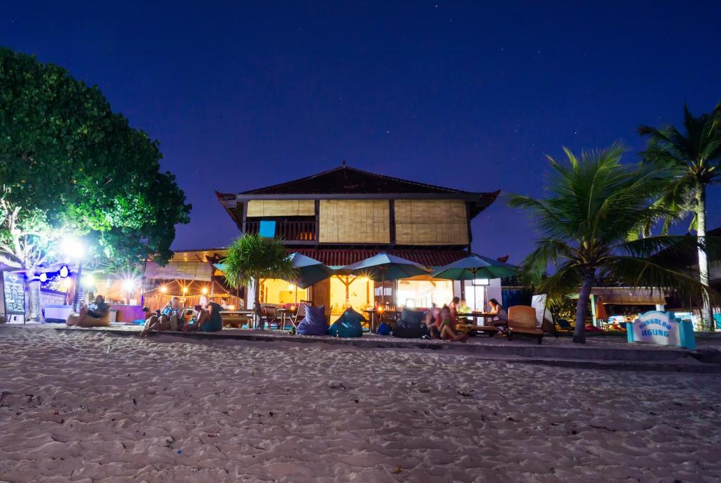 a building with people sitting outside of it at night at Agung Lembongan Bungalow in Nusa Lembongan