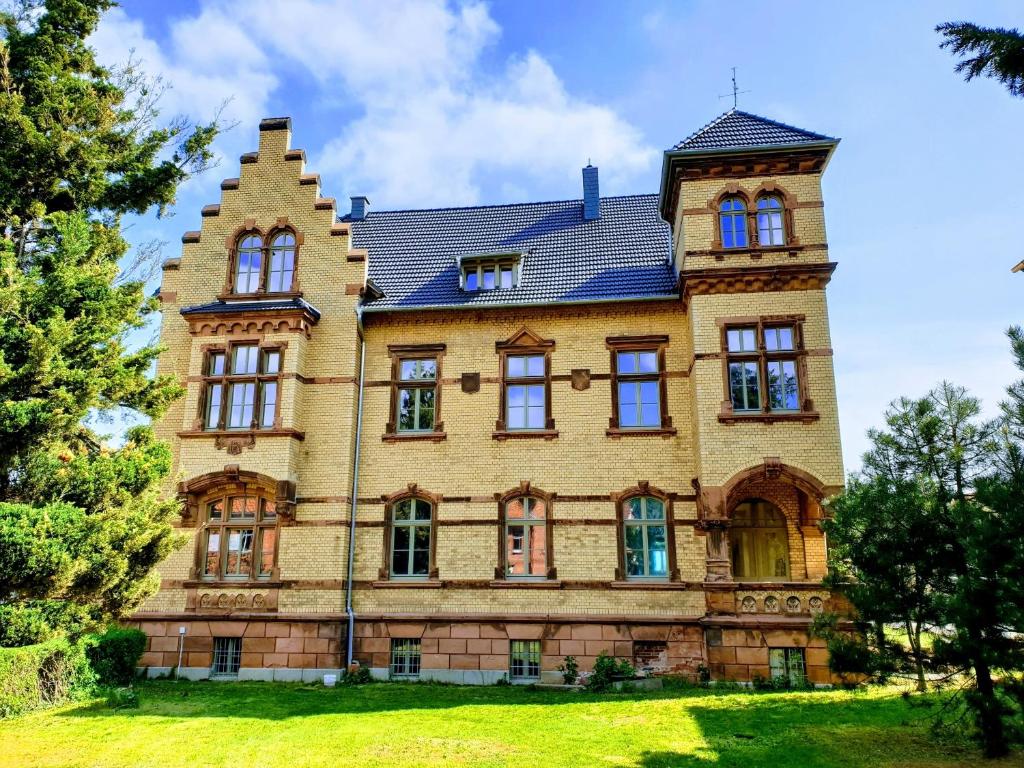 uma grande casa de tijolos com um telhado de gambrel em Villa Bianca am Huy em Dingelstedt
