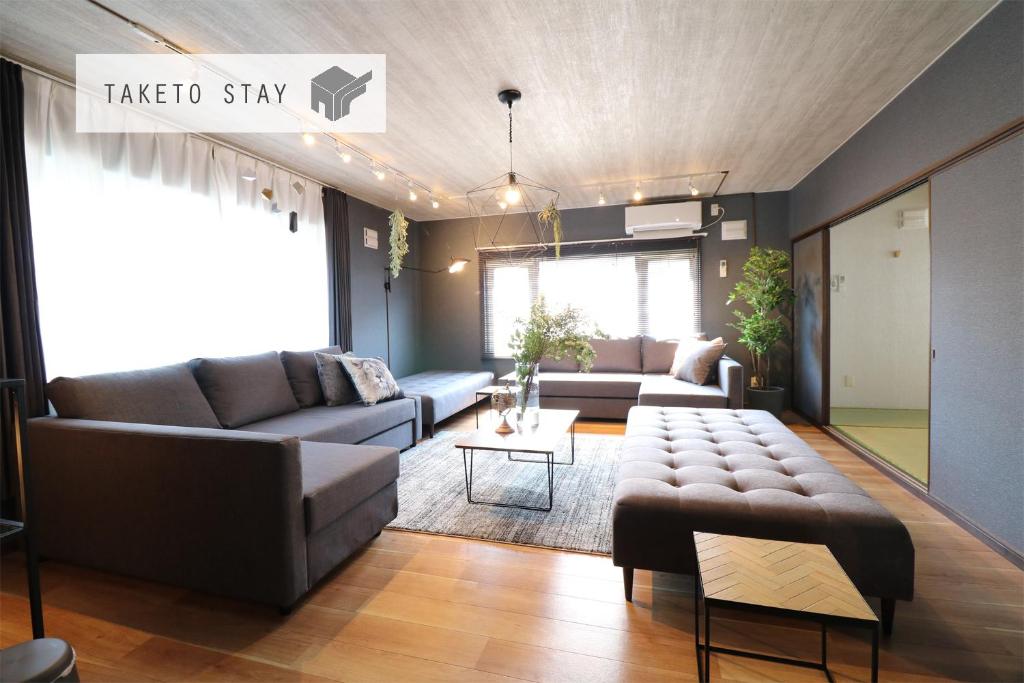 uma sala de estar com um sofá e uma mesa em HH house sapporo em Sapporo