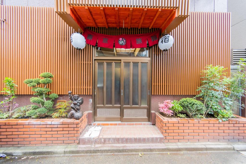 una puerta de entrada de una casa con una cortina roja encima en Tokyo SA Ryokan, en Tokio