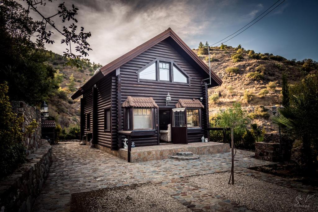 a wooden house with a mountain in the background at *2 bdr log house /mountains/Queen bed/fireplace in Gourri