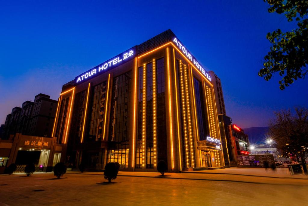 a large building with lights on it at night at Atour Hotel (Tianshui Hige Speed Railway South Xihuang Avenue) in Tianshui