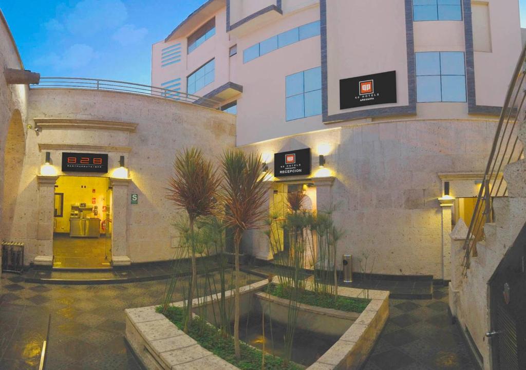 a building with yellow doors and a courtyard with trees at qp Hotels Arequipa in Arequipa