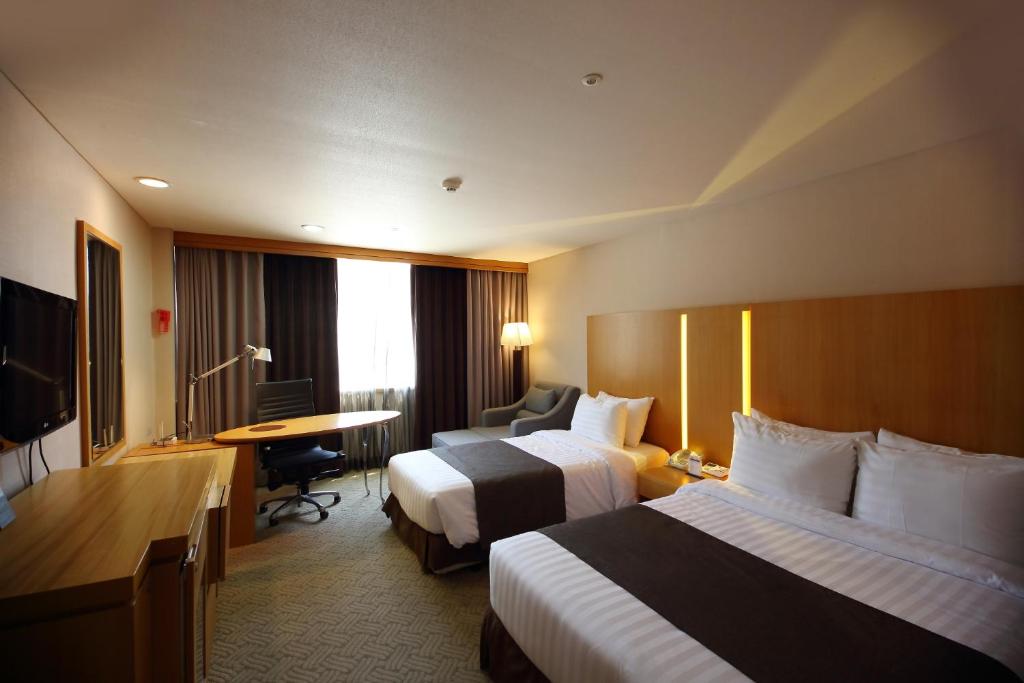 Postel nebo postele na pokoji v ubytování Ramada by Wyndham Songdo