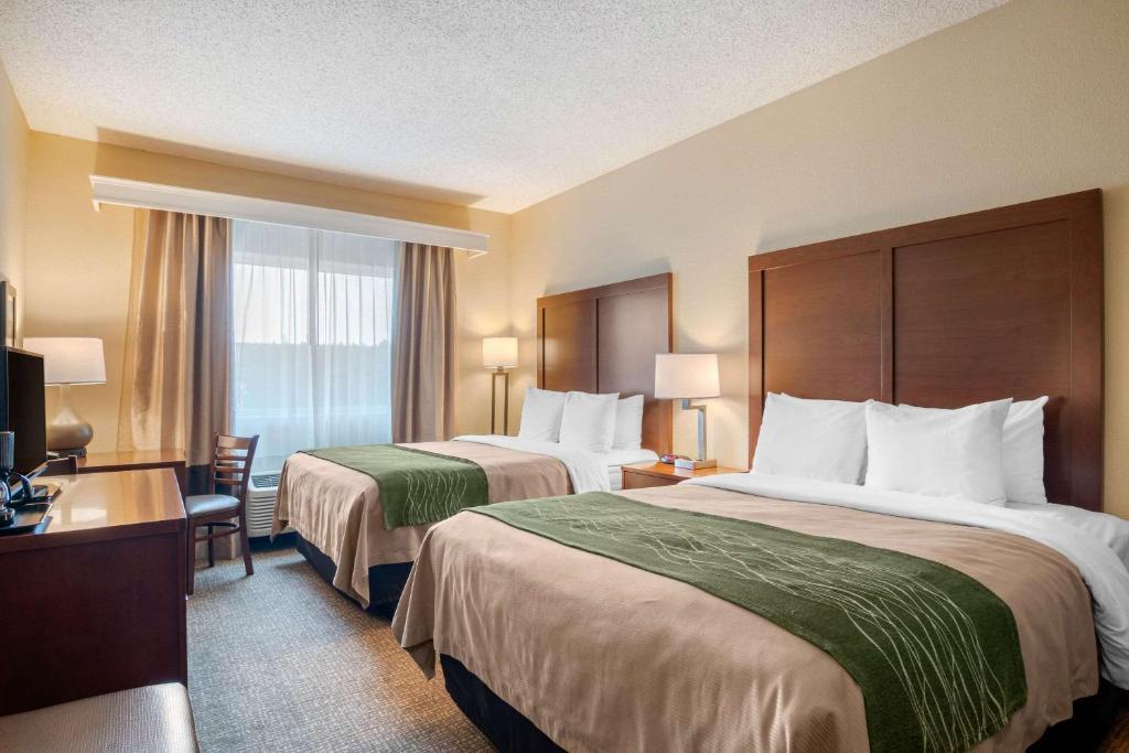 a hotel room with two beds and a television at Comfort Inn Medford North in Medford