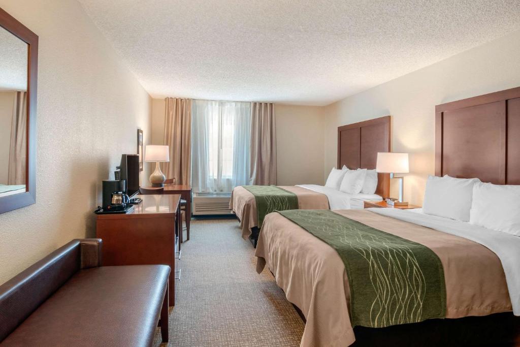 a hotel room with two beds and a television at Comfort Inn Medford North in Medford