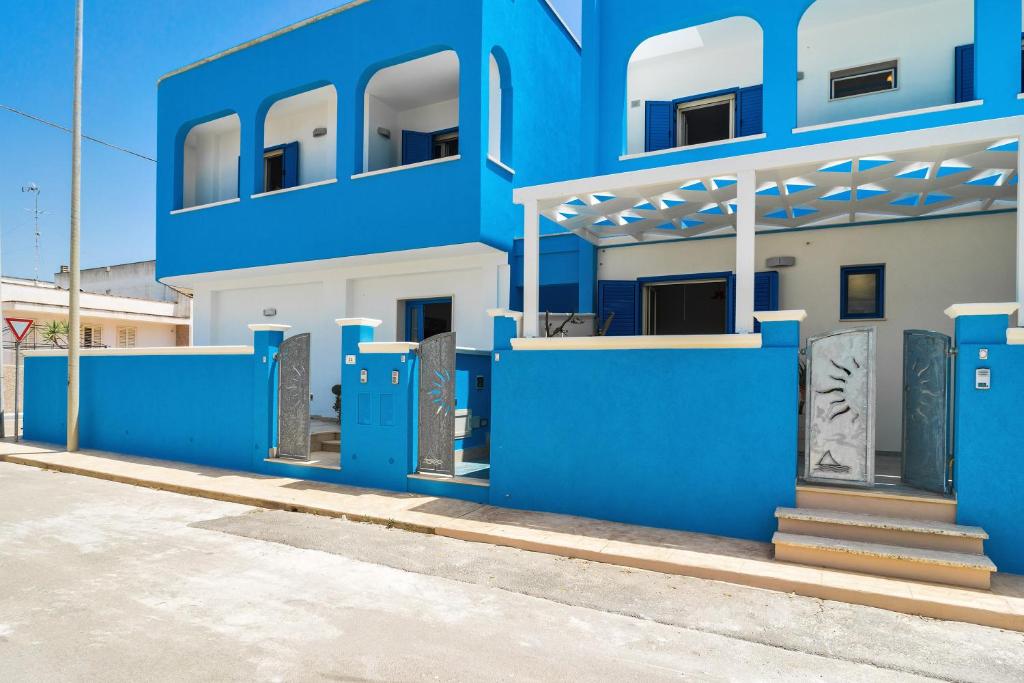 a blue building with blue doors on a street at Lido Marini Seahouses in Lido Marini