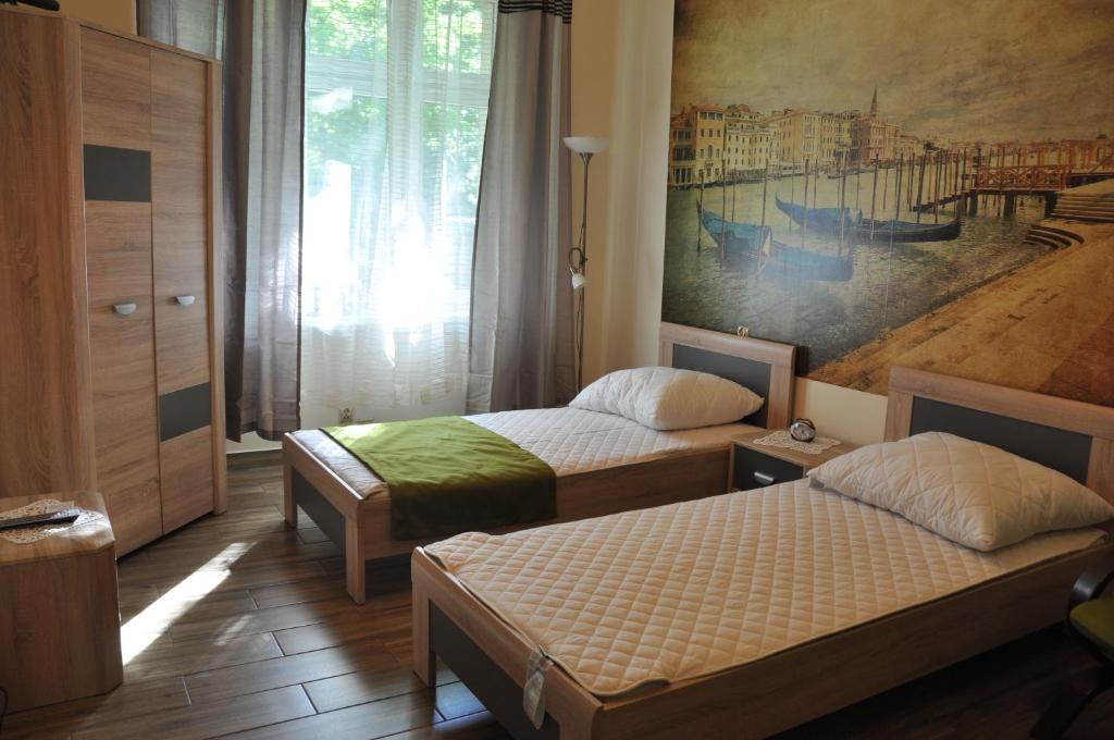 um quarto com duas camas e um quadro na parede em Wenecja 4A by Homeprime na Cracóvia