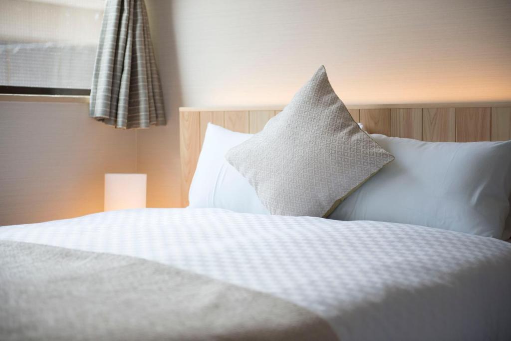 Postel nebo postele na pokoji v ubytování Hotel ZIZI Kyoto Gion