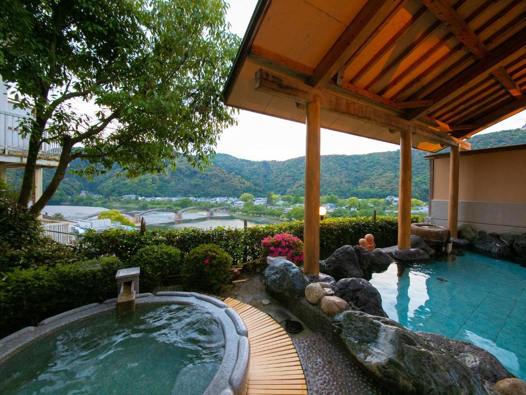 einen Whirlpool in einem Garten neben einem Gebäude in der Unterkunft Iwakuni Kokusai Kanko Hotel in Iwakuni