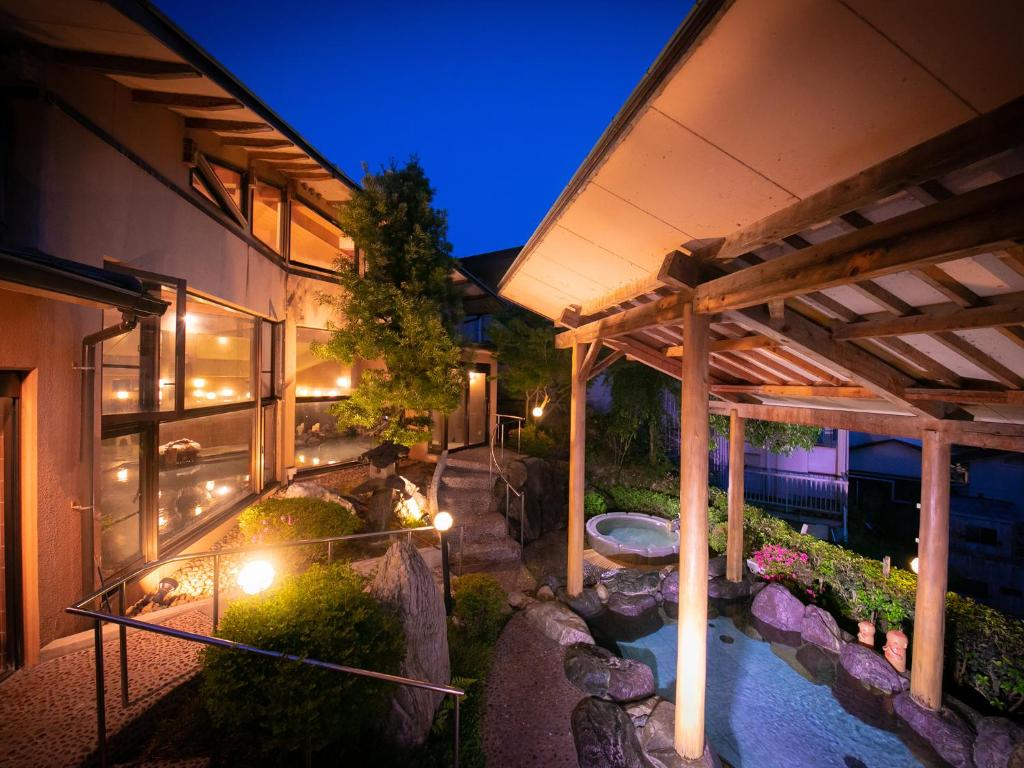 Elle offre une vue sur l'extérieur d'une maison dotée d'une terrasse et d'un étang. dans l'établissement Iwakuni Kokusai Kanko Hotel, à Iwakuni