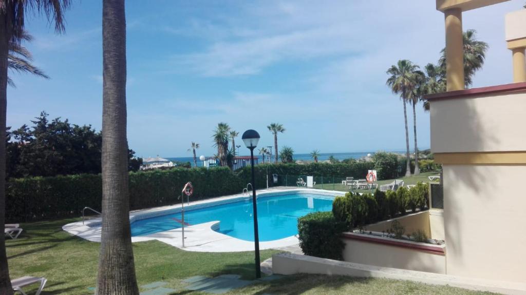 una piscina en un patio con palmeras en Romana Playa 7, Soleuropa en Marbella