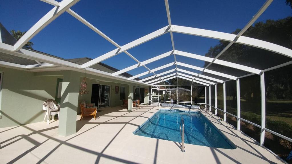 a patio with a swimming pool with a glass roof at Villa Willow Wood - Golfcourse in Inverness