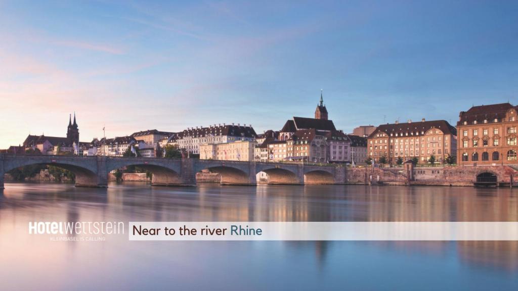 a bridge over a river in a city with buildings at Hotel Wettstein in Basel