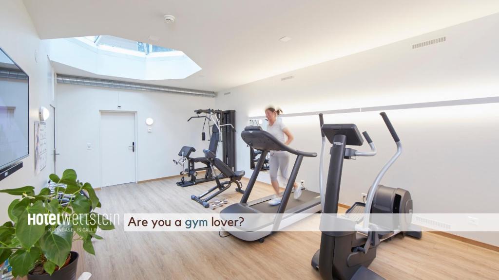a woman exercising on a treadmill in a gym at Hotel Wettstein in Basel