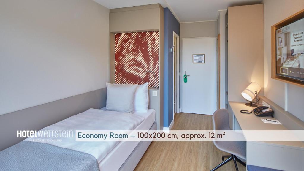 a hotel room with a bed and a desk and a window at Hotel Wettstein in Basel