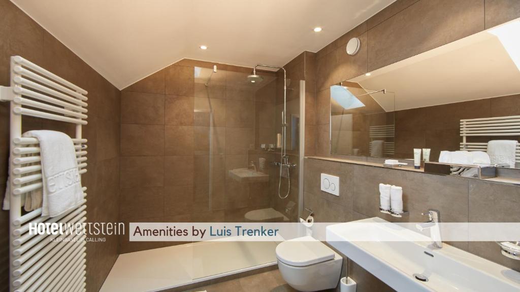 a bathroom with a shower and a toilet and a sink at Hotel Wettstein in Basel