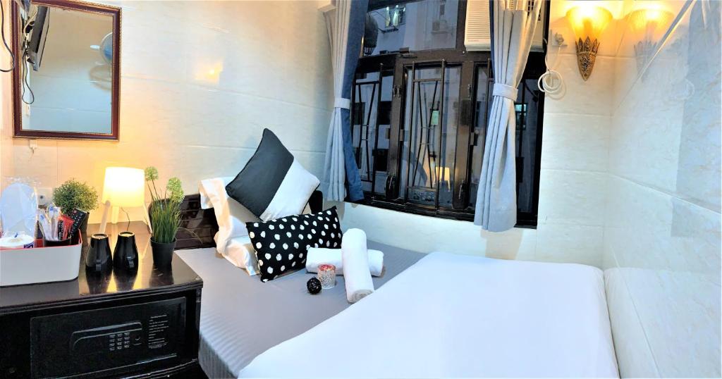 Un dormitorio con una cama blanca y una ventana. en Sydney Hostel, en Hong Kong