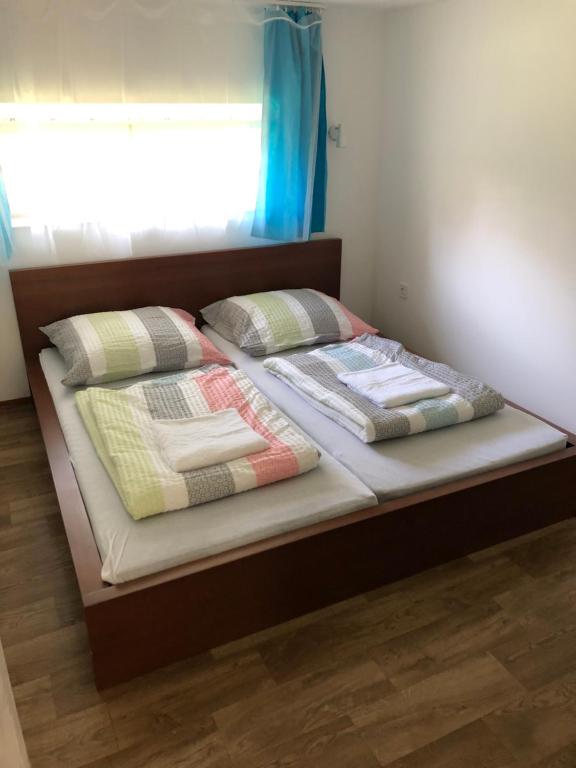 uma cama com duas almofadas com uma janela em Schmidt Apartman 2. em Csopak