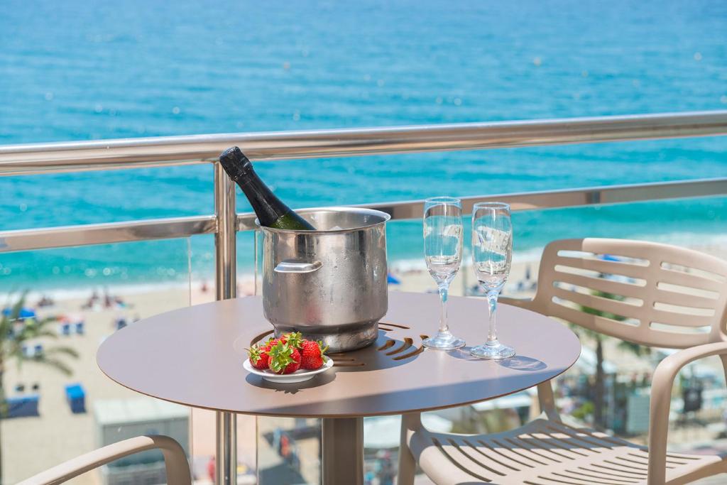 a table with a bottle of wine and two glasses at Hotel Marsol in Lloret de Mar