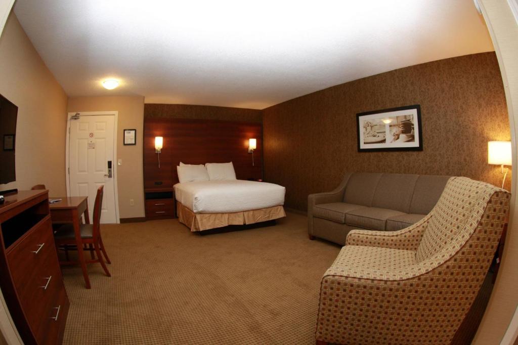 a hotel room with a bed and a couch at Budget Host Inn & Suites in Saint Ignace