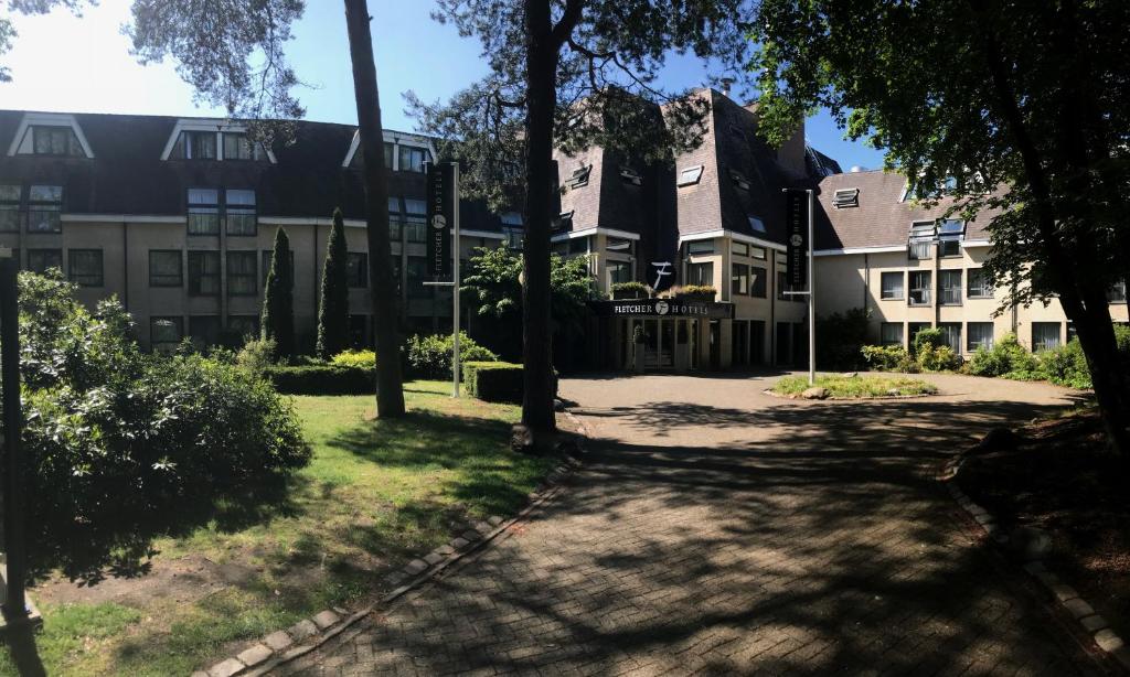 een groot gebouw met bomen ervoor bij Fletcher Hotel Restaurant Epe-Zwolle in Epe