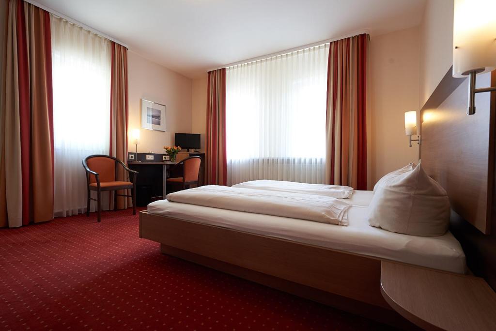 a hotel room with a large bed and a desk at Hotel Gasthof König Karl in Freudenstadt