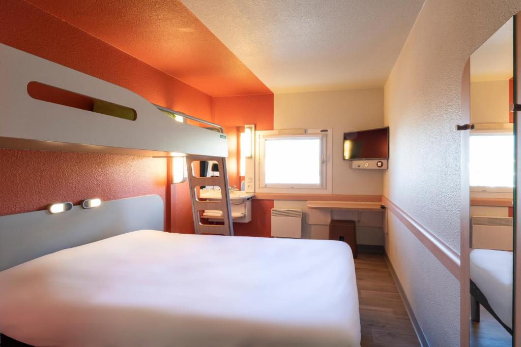 Habitación pequeña con cama y escritorio. en ibis budget Viry-Chatillon A6, en Viry-Châtillon