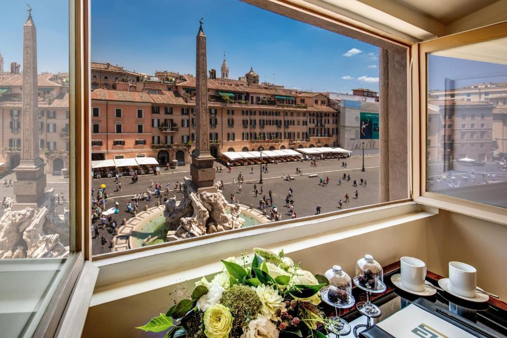 ein Fenster mit Stadtblick vom Tisch in der Unterkunft Eitch Borromini Palazzo Pamphilj in Rom