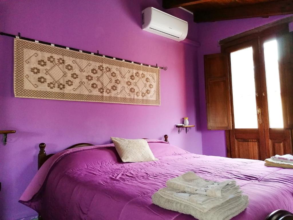 una camera da letto viola con un letto con pareti viola di Casa Susanna Rural Sardinia a Sini