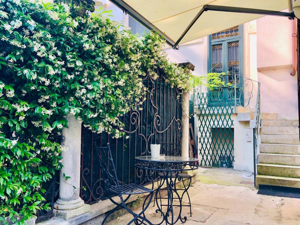 un tavolo esterno con ombrellone davanti ad un cancello di Torre dell'Orologio Apartment a Padova