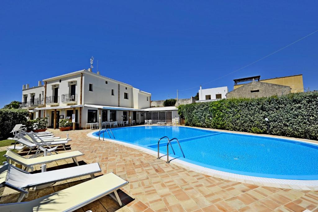 a swimming pool in front of a house at Resort Santa Maria Hotel in Birgi Vecchi